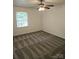 Well-lit bedroom featuring a ceiling fan and gray carpeting at 2819 Royal Ridge Ln, Charlotte, NC 28212