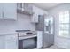 Modern white kitchen with stainless steel appliances and quartz countertops at 12914 Mosby Ln, Charlotte, NC 28273
