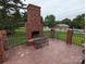 Brick outdoor fireplace with seating area on a spacious patio at 5916 Meadowmere Dr, Monroe, NC 28110