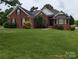 Brick house with a large front yard and mature landscaping at 5916 Meadowmere Dr, Monroe, NC 28110