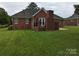 Rear view of brick house, showcasing patio and landscaping at 5916 Meadowmere Dr, Monroe, NC 28110