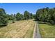 Large lot with gravel driveway and wooded area at 10910 Archer Rd, Davidson, NC 28036
