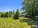 House nestled in a spacious grassy lot with lush trees at 10910 Archer Rd, Davidson, NC 28036