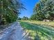 A rural road runs through a grassy field bordered by trees at 10910 Archer Rd, Davidson, NC 28036