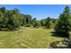 Wooded lot with grassy field and a pile of wood at 10910 Archer Rd, Davidson, NC 28036