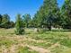 Open field with trees and a large boulder at 10910 Archer Rd, Davidson, NC 28036