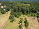 Aerial view of property with open fields and wooded areas at 10910 Archer Rd, Davidson, NC 28036