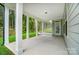 Covered back porch with concrete flooring, white columns, and wooded views at 2016 Cedar Falls Dr # 7, Waxhaw, NC 28173