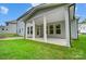 House back porch with gray siding, white columns, and grassy backyard at 2016 Cedar Falls Dr # 7, Waxhaw, NC 28173