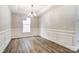 Dining room with elegant wainscoting, wood-look flooring, and a stylish chandelier at 130 Summerhill Dr # 16, Mooresville, NC 28115