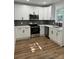 Modern kitchen with white cabinets, gray backsplash, and stainless steel appliances at 115 Palmer St, Shelby, NC 28150