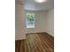 Well-lit bedroom with a large window and wood floor at 115 Palmer St, Shelby, NC 28150