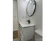 Clean bathroom with white vanity, round mirror, and vinyl flooring at 115 Palmer St, Shelby, NC 28150