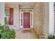 Red front door with brick exterior and porch at 8714 Brideswell Ln, Charlotte, NC 28278