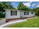 Single-wide mobile home with brick skirting, walkway, and satellite dish at 1219 Neely Smith Ln, Gastonia, NC 28056
