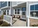 Small front porch with white railing and comfortable seating at 5919 Wetlands Aly, Charlotte, NC 28215