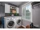 Bright laundry room with washer, dryer, and shelving at 634 Carson Rd, Gastonia, NC 28052