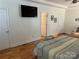 Main bedroom with hardwood floors, large TV, and access to bathroom at 115 Anson Dr, China Grove, NC 28023