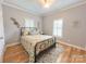 Bedroom with floral bedding, wood floors, and window shutters at 115 Anson Dr, China Grove, NC 28023