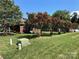 Landscaped side yard with lush green grass and vibrant crape myrtles at 115 Anson Dr, China Grove, NC 28023