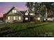 Two-story brick home with a landscaped lawn at dusk at 101 Mcalway Rd, Charlotte, NC 28211