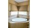 Relaxing bathroom featuring a corner soaking tub and window at 4642 King Crowder Dr, Gastonia, NC 28052