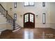 Two-story entryway with hardwood floors, a grand staircase, and double doors at 2708 Chilton Pl, Charlotte, NC 28207