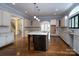 Modern kitchen with a large island, white cabinets, and hardwood floors at 2708 Chilton Pl, Charlotte, NC 28207