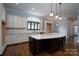 Modern kitchen with a large island, white cabinets, and hardwood floors at 2708 Chilton Pl, Charlotte, NC 28207