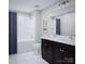 Bathroom with a bathtub, double vanity, and dark cabinets at 1008 Briar Well St, Mint Hill, NC 28227