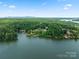 Aerial view of house on lake with a beautiful shoreline and lush trees at 144 Hickory Hollow Ln, Taylorsville, NC 28681