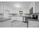 Updated kitchen with white cabinets, granite countertops, and tile backsplash at 144 Hickory Hollow Ln, Taylorsville, NC 28681