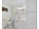Clean bathroom with white vanity, toilet and a large mirror at 144 Hickory Hollow Ln, Taylorsville, NC 28681