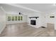 Bright living room with wood-look floors, fireplace, and large windows at 144 Hickory Hollow Ln, Taylorsville, NC 28681