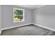 Bright bedroom with grey walls, wood-look flooring, and a large window at 8433 Rittenhouse Cir, Charlotte, NC 28270