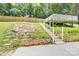 Stone steps leading up to a wooden deck overlooking the backyard landscape and stone fountain at 8433 Rittenhouse Cir, Charlotte, NC 28270