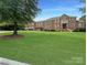 Large brick home with lush green lawn and driveway at 9100 Woodhall Lake Dr, Waxhaw, NC 28173