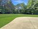 Landscaped backyard with large lawn and concrete patio at 9100 Woodhall Lake Dr, Waxhaw, NC 28173