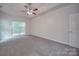 Large bedroom with grey carpet, ceiling fan and window at 6232 Hickory Cove Ln, Charlotte, NC 28269