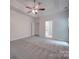 Well-lit bedroom with carpet, ceiling fan and access to bathroom at 6232 Hickory Cove Ln, Charlotte, NC 28269