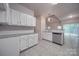 White kitchen cabinets, granite countertops, and tile floors at 6232 Hickory Cove Ln, Charlotte, NC 28269
