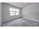 Bright bedroom with grey carpet, double closet, and window at 6232 Hickory Cove Ln, Charlotte, NC 28269