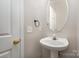 Small powder room with pedestal sink and oval mirror at 1804 Robinwood Village Dr, Gastonia, NC 28054