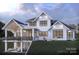 Modern farmhouse with large deck, patio below, and sloped backyard at 337 Tradition Dr, Mount Gilead, NC 27306