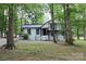 White house with black accents, nestled among lush trees at 310 Chaney St, Wingate, NC 28174