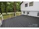Dark composite deck with cable railing overlooks wooded area at 310 Chaney St, Wingate, NC 28174