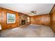 Living room featuring wood paneling, a stone fireplace, and carpeted floors at 1418 Oakwood Ave, Kannapolis, NC 28081