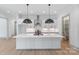 Modern kitchen with white cabinets, a large island, and black pendant lights at 1529 Beckwith Pl, Charlotte, NC 28205