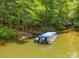 Covered pontoon boat on a private dock nestled in a wooded area at 00 Rivendell Rd # 7, Denver, NC 28037