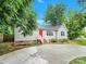 One-story home with light beige siding, red door, and a concrete driveway at 919 Edgemont Ave, Belmont, NC 28012